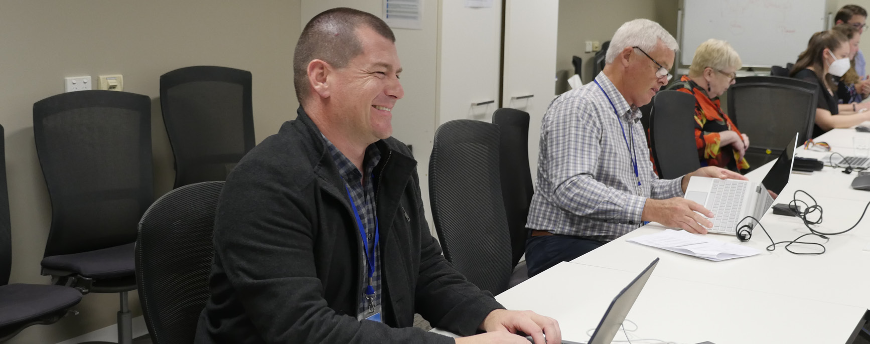 5 people sitting at a office board room table